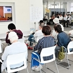 百条委員会を中継するモニターに見入る市民ら＝洲本市役所