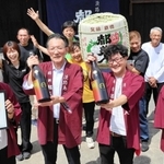 世界一の酒に選ばれた都美人の純米吟醸「太陽」と喜ぶ社員ら＝南あわじ市榎列西川