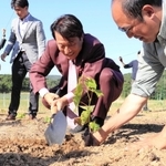 ブドウの苗を植えるパソナグループの南部靖之代表（右から２人目）とアドバイザーの大岡弘武さん（右端）＝淡路市野島常盤