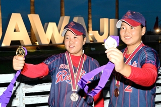 全国大会で優勝を果たし、金メダルを手にする福岡結菜投手（左）と千葉如乃捕手＝洲本市安乎町平安浦