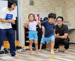 ジャンプアップ教室を指導する江本暁宣さん（右）と清水真澄さん（左）。軽快な音楽に合わせ、子どもたちが跳びはねる＝南あわじ市阿万上町