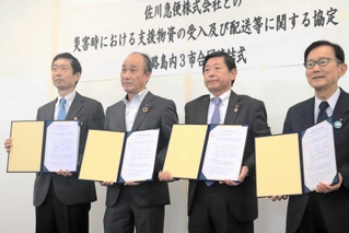 協定書を持つ（左から）守本憲弘南あわじ市長、谷本信幸佐川急便関西支店長、上崎勝規洲本市長、門康彦淡路市長＝淡路市生穂新島