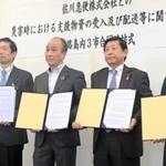 協定書を持つ（左から）守本憲弘南あわじ市長、谷本信幸佐川急便関西支店長、上崎勝規洲本市長、門康彦淡路市長＝淡路市生穂新島