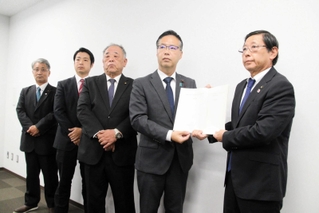 市議会の福本巧議長（右から２人目）らから百条委の報告書を受け取った上崎勝規市長（右端）＝洲本市役所