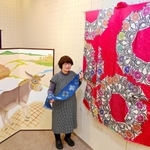 本年度の兵庫工芸展で大賞に輝いた振り袖（右）や、昨年度の日展で入選したロバのびょうぶ絵などの作品と中来田万里さん＝サンシャインホール