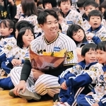 児童に囲まれて笑顔を見せる村上投手＝賀集小学校