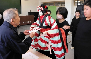 畑崎廣敏さん（左）から目録を受け取る南淡中学校郷土芸能部の生徒＝南淡中学校
