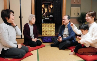 美昭さんの思い出を話す裏井宏さん（左から３人目）、妻直子さん（左端）、母とみ子さん（左から２人目）、息子の斗真ちゃんを抱く長女の美佳さん（右端）＝淡路市富島