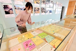 全国から寄せられた励ましの手紙や被災地の写真などが並ぶ展示会場＝淡路市立津名図書館