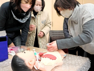 人形を使って医療的ケアの実践をする参加者＝南あわじ市志知佐礼尾