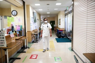 診療所内を歩く井宮雅宏さん。今もここで地元住民と向き合う＝淡路市育波（撮影・古田真央子）