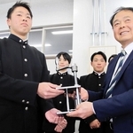 完成した線香作りの機械をパルシェ香りの館の葉坂光則さん（右）とともに手にする洲本実業高の生徒＝洲本実業高校