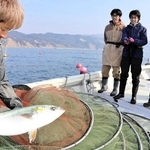 吉備国際大の学生に網にかかった魚について説明する漁師の西野恵介さん（手前）＝南あわじ市沖