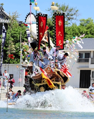 しぶきを上げながら勢いよく海へ突入するだんじり＝南あわじ市沼島