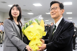 職員から花束を受け取った門康彦氏＝淡路市役所