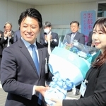 拍手で迎える職員の前で花束を受け取る戸田敦大市長＝淡路市役所