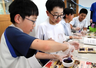 乳鉢などを使って、お香の原料を混ぜる淡路市立一宮小と宍粟市立一宮北小の児童＝淡路市北山、一宮小学校