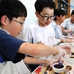 乳鉢などを使って、お香の原料を混ぜる淡路市立一宮小と宍粟市立一宮北小の児童＝淡路市北山、一宮小学校