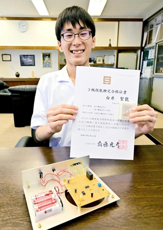 合格証書を手に笑顔の白井聖龍さん＝洲本実業高校