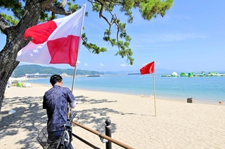 危険を知らせる津波フラッグを準備する洲本市関係者＝洲本市の大浜海水浴場（撮影・内田世紀）