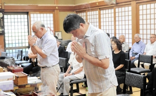 亡くなった予科練生らの冥福を祈り、手を合わせる参列者＝春日寺