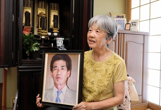 原田修一さんの写真を手に思い出を語る妻の満恵さん＝淡路市下田