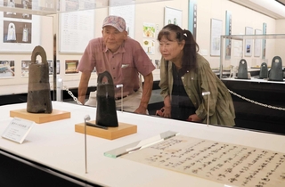 慶野銅鐸（左）、慶野中の御堂銅鐸とその舌。中の御堂銅鐸が発見された時の古文書の写しも並ぶ＝玉青館