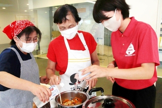 備蓄品を使って料理を作る防災女子の学生や市消防団女性隊のメンバーら＝淡路市防災あんしんセンター