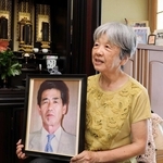 原田修一さんの写真を手に思い出を語る妻の満恵さん＝淡路市下田