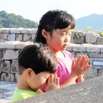 今年の終戦の日、戦没学徒を慰霊する塔の前で子どもが手を合わせていた＝南あわじ市阿万塩屋町