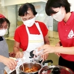備蓄品を使って料理を作る防災女子の学生や市消防団女性隊のメンバーら＝淡路市防災あんしんセンター