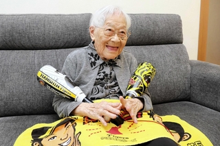 阪神グッズを手に笑顔の蔭山とよみさん＝南あわじ市阿万東町