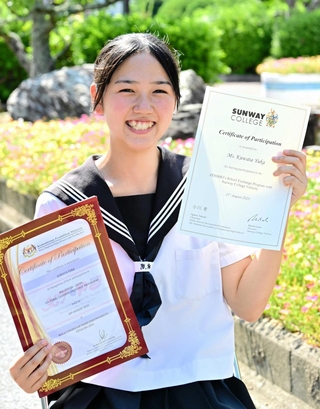 海外研修事業の参加認定証などを手にする桑田由華さん＝洲本実業高校