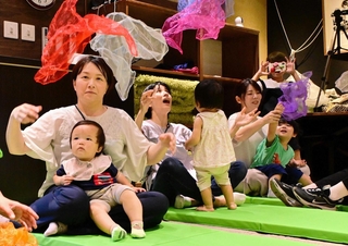 子育て中の母親を支援する「ママカフェ」がオープンし、音楽による母子支援「ららばいプロジェクト」を体験する親子連れら＝ＹＯＲＩＳＯＩ米田家