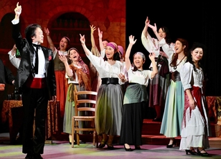 世界的オペラ歌手の藤井泰子さん（右端）、成田博之さん（左端）のバックで合唱と演技を披露する淡路島の一般参加者ら＝旧アソンブレホール