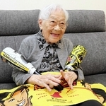 阪神グッズを手に笑顔の蔭山とよみさん＝南あわじ市阿万東町