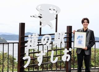 「淡路うず助」の原画を持つ松島聡さん＝南あわじ市福良丙
