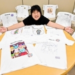 父親の手でＴシャツとなった作品の展示に、顔をほころばせる清水華花さん＝東浦図書館