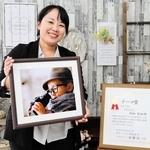 「今後の自信に」と富士フイルム営業写真コンテストで入賞した作品を手に笑顔の岡田智加さん＝洲本市海岸通２