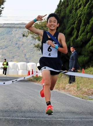 笑顔でゴールテープを切る男子・青雲の中山和希選手＝城戸アグリ公園