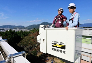 電気工事士の同伴で高所作業車を体験する生徒（右）＝洲本実業高校