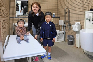 ユニバーサルシートを前に「大好きな大浜だから絶対に付けたかった」と話す古田愛美さん（中央）＝大浜公園