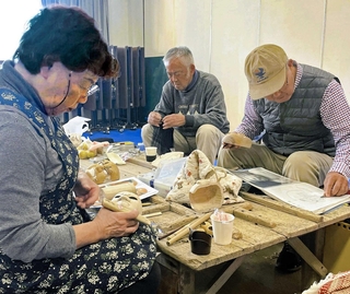 「木偶づくり講座」で頭を彫るメンバー。不思議と自分や家族の顔に似てくるという＝淡路人形浄瑠璃資料館