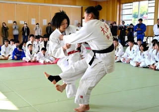 子どもたちの前で、得意の小外刈りを披露する中村美里さん（手前左）＝蒼開高校