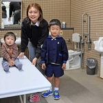 ユニバーサルシートを前に「大好きな大浜だから絶対に付けたかった」と話す古田愛美さん（中央）＝大浜公園