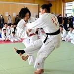 子どもたちの前で、得意の小外刈りを披露する中村美里さん（手前左）＝蒼開高校