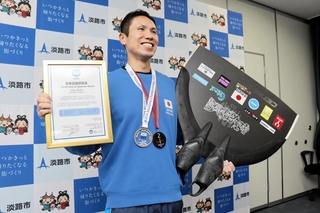 愛用のフィンと日本記録認定証を手にする杉谷大地さん＝淡路市役所