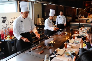 シェフの指導でステーキを焼く（左から）杉本裕太郎選手と福田周平選手＝淡路市岩屋