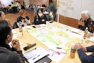 グループごとに地域創生のアイデアを出し合う参加者。模造紙や付箋を使って、まとめていった＝洲本市塩屋１