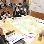 グループごとに地域創生のアイデアを出し合う参加者。模造紙や付箋を使って、まとめていった＝洲本市塩屋１